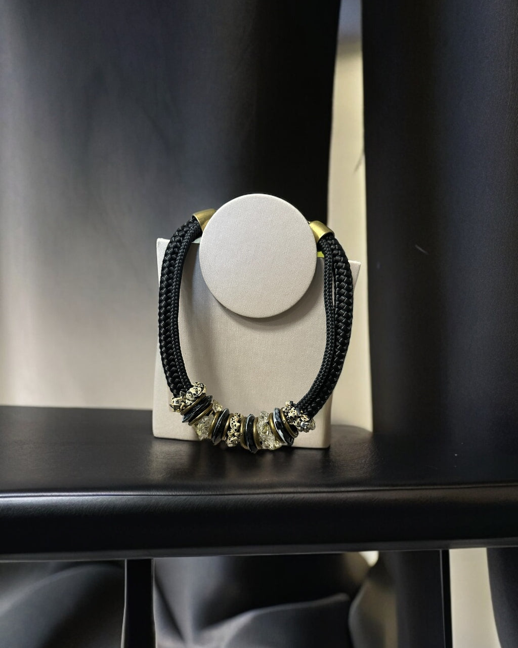 Colar Inês com aro redondo branco e cordão preto trançado com detalhes dourados