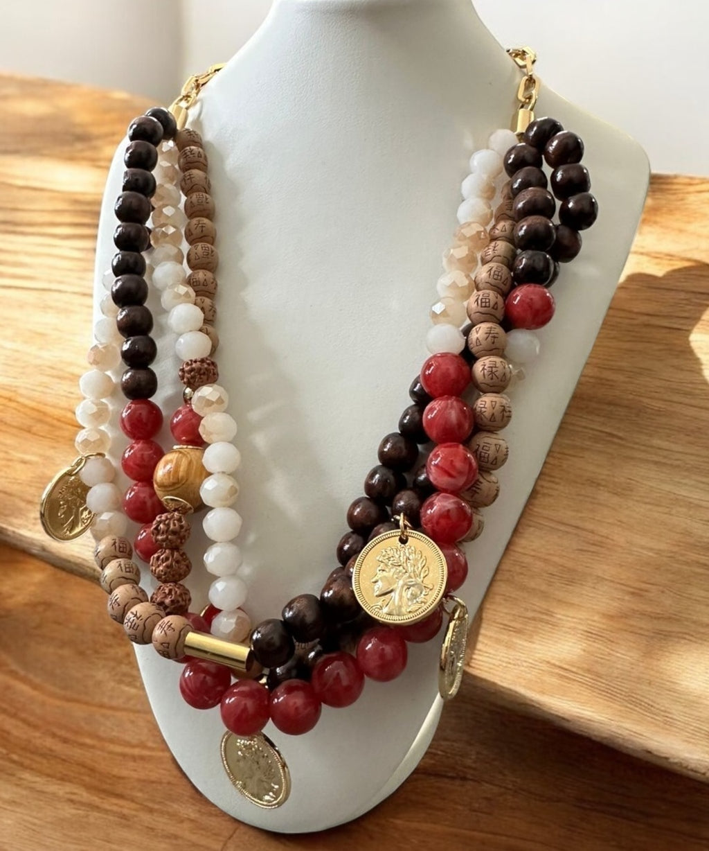 Colar de miçangas com pingente dourado e pedras vermelhas, brancas e escuras