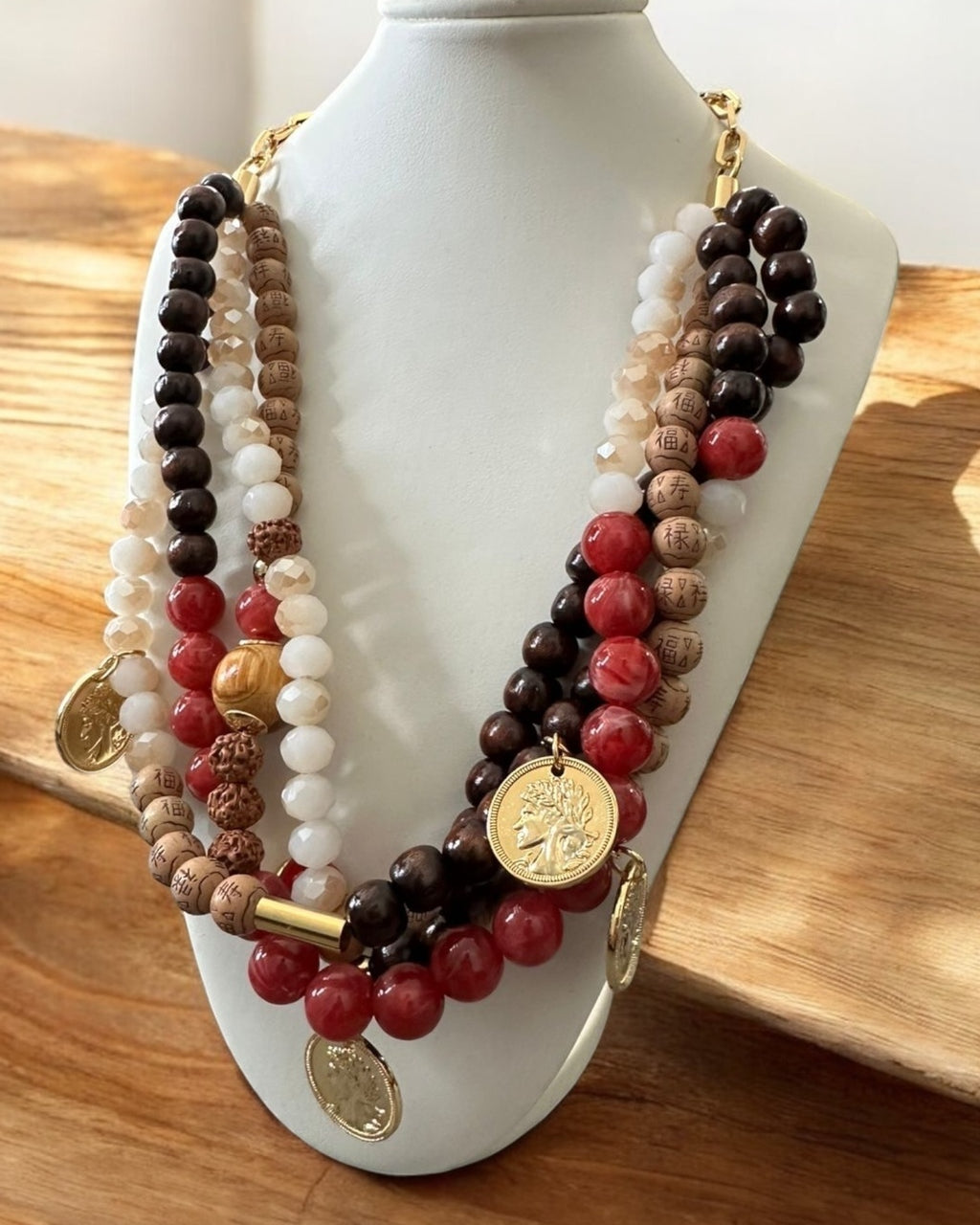 Colar de miçangas com pingente dourado e pedras vermelhas, brancas e escuras
