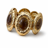 Pulseira de metal dourado com três pedras ovais marrom