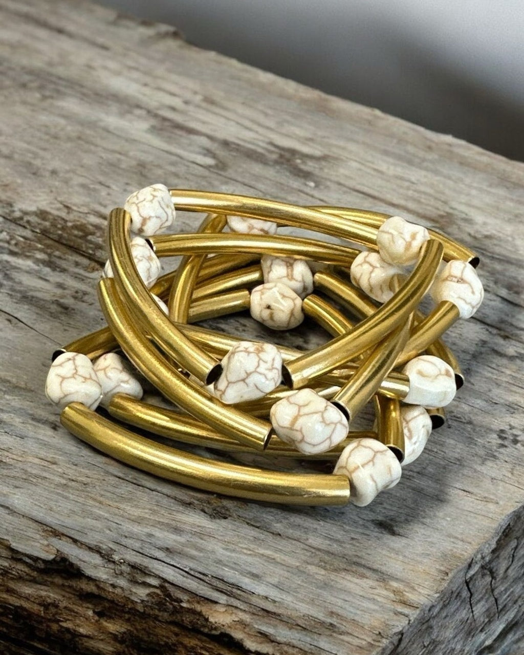 Mix de pulseiras Indra com braceletes dourados e contas brancas mescladas