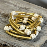 Mix de pulseiras Indra com braceletes dourados e contas brancas mescladas
