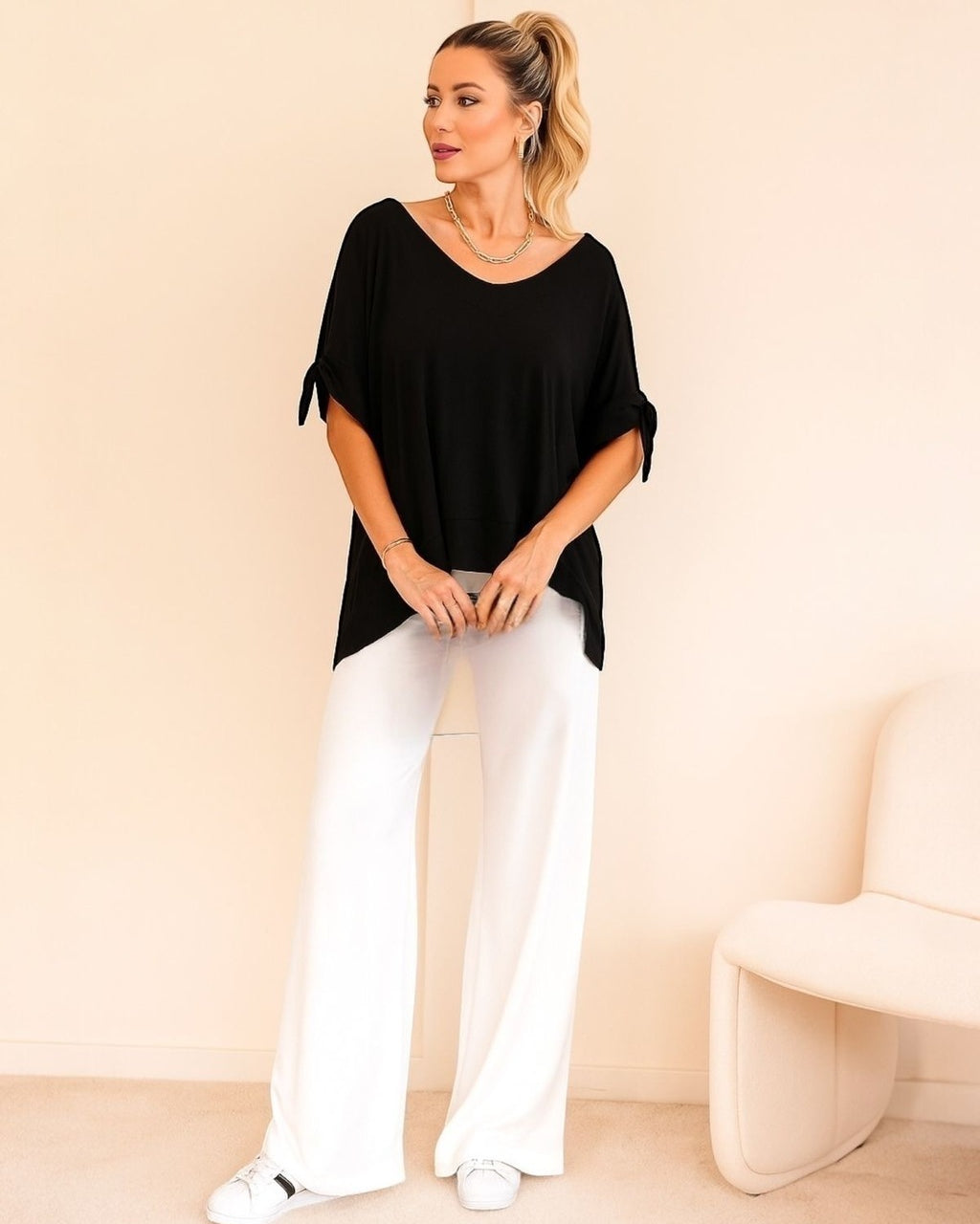 Blusa preta ampla com decote em V e mangas amplas presas por laços laterais