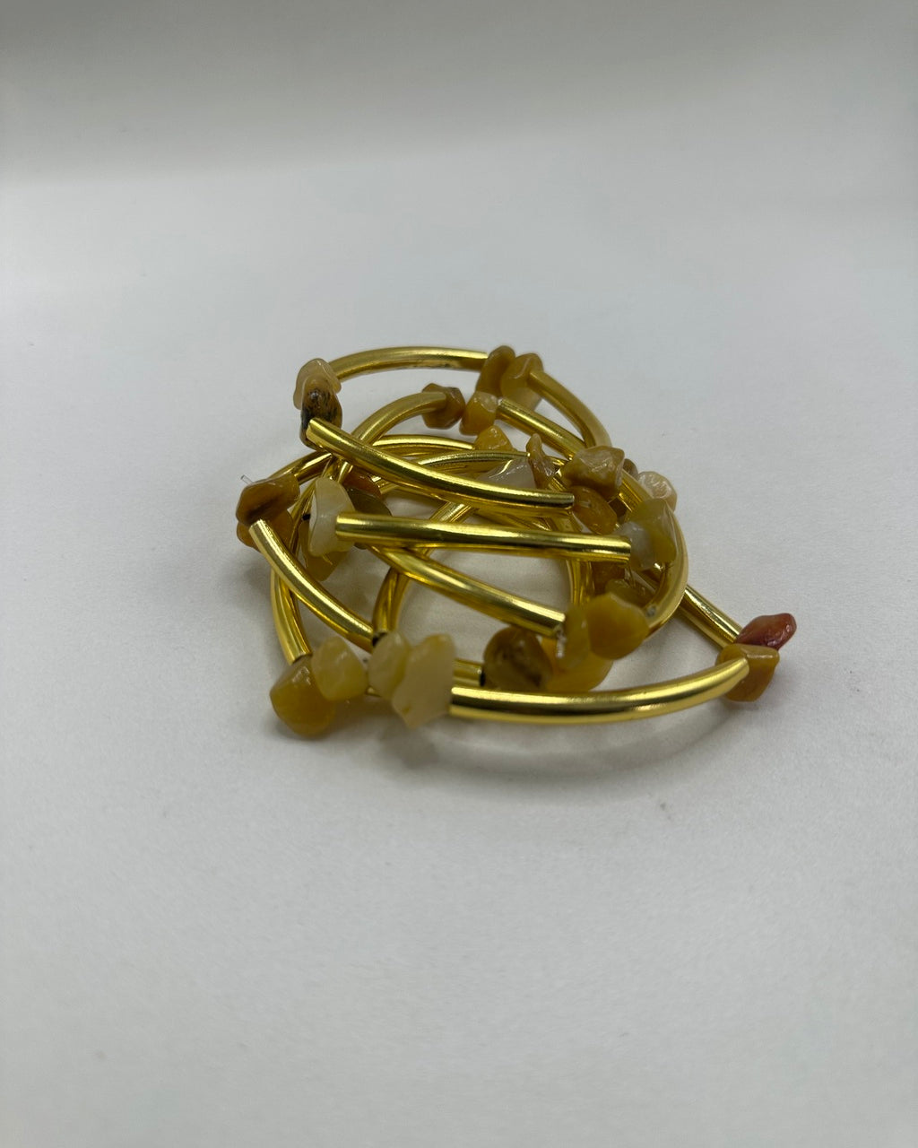 Pulseira folheada dourada com pedras translúcidas claras e detalhe marrom