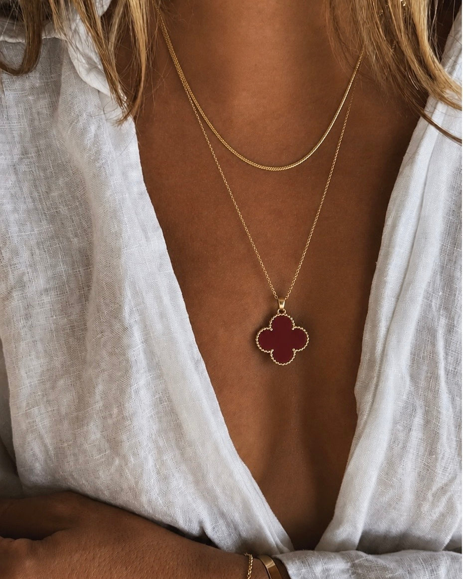 Colar dourado com pingente trevo vermelho