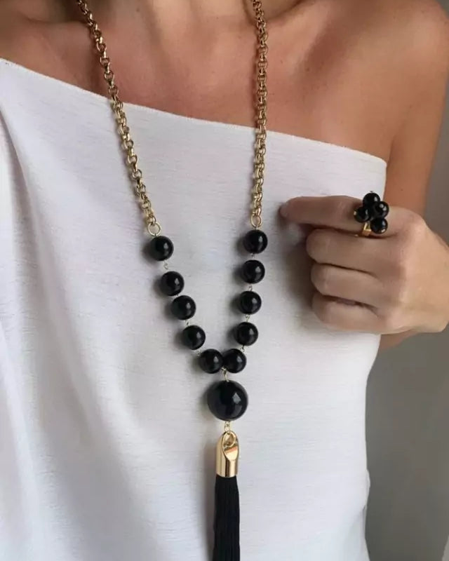 Colar Louise com correntes douradas, contas pretas e pingente com franja