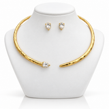 Conjunto de colar e brincos Amélia dourados, com pedras transparentes em formato de gota.
