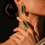 Anel Canoa com pedra verde facetada e aro dourado com borda de esferas