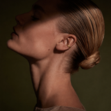 Ear cuff dourado com pedras brilhantes no lóbulo da orelha