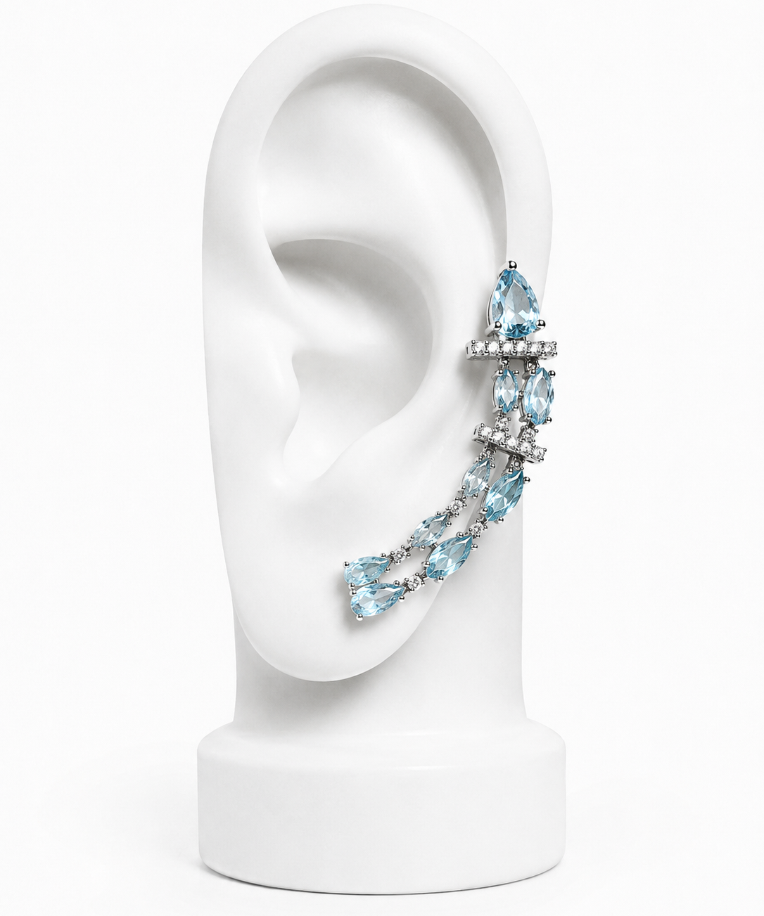 Brinco ear cuff com pedras azul-céu e corrente cravejada, metal prateado.