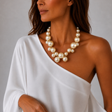 Colar maxi de pérolas em volta única no pescoço, com vestido de um ombro