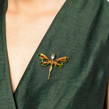 Broche de libélula no peito, metal dourado e asas esmaltadas verde e laranja