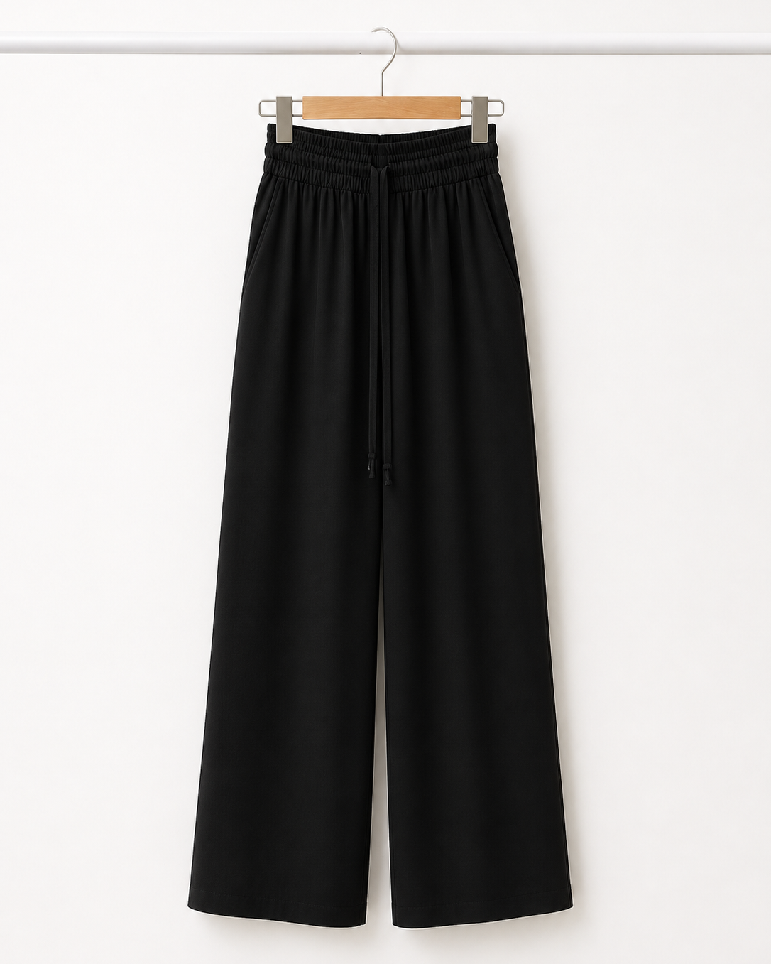 Calça pantalona preta com cós elástico e cordão central, pernas largas
