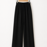 Calça pantalona preta com cós elástico e cordão central, pernas largas