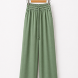 Calça pantalona verde com cós elástico e cordão, caimento solto
