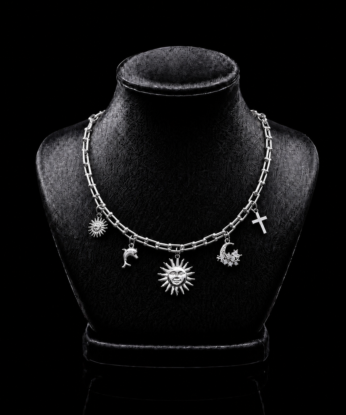 Colar de corrente prateada com pingentes sol, lua e estrelas.