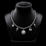 Colar de corrente prateada com pingentes sol, lua e estrelas.
