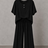 Conjunto preto: blusa tipo henley com botões e calça pantalona de cintura elástica