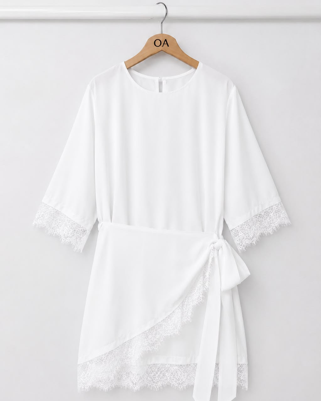 Vestido branco com renda nas mangas, faixa amarrada na cintura, recorte assimétrico