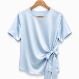 Blusa de cetim azul claro com gola redonda e faixa amarrada na frente.