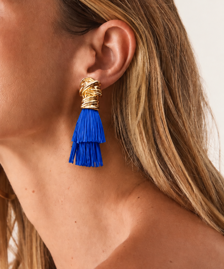 Brinco dourado com franjas azuis em camadas, detalhe na orelha