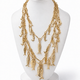 Colar dourado fosco com correntes em camadas e pingentes pendurados