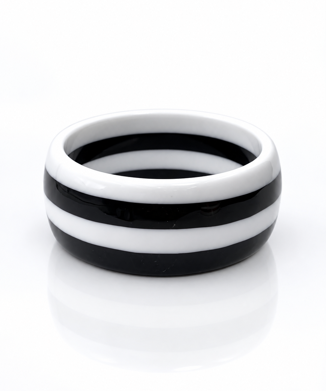 Pulseira de aro com faixas pretas e brancas alternadas, estilo bangle.