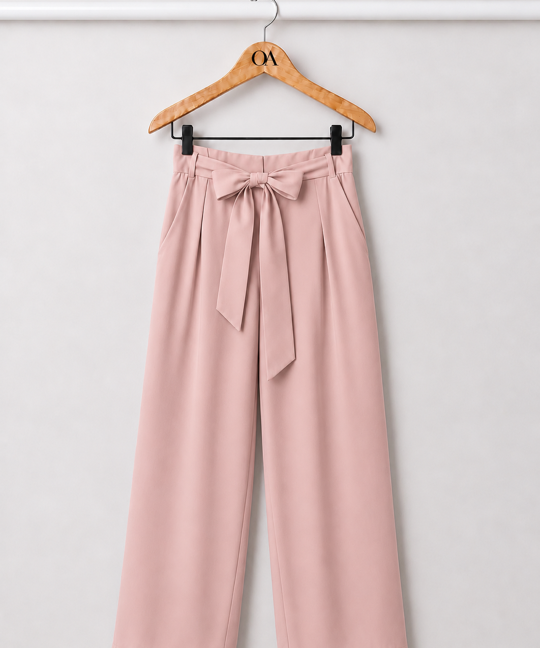 Calça rosa com laço na cintura e pernas amplas, com bolsos laterais