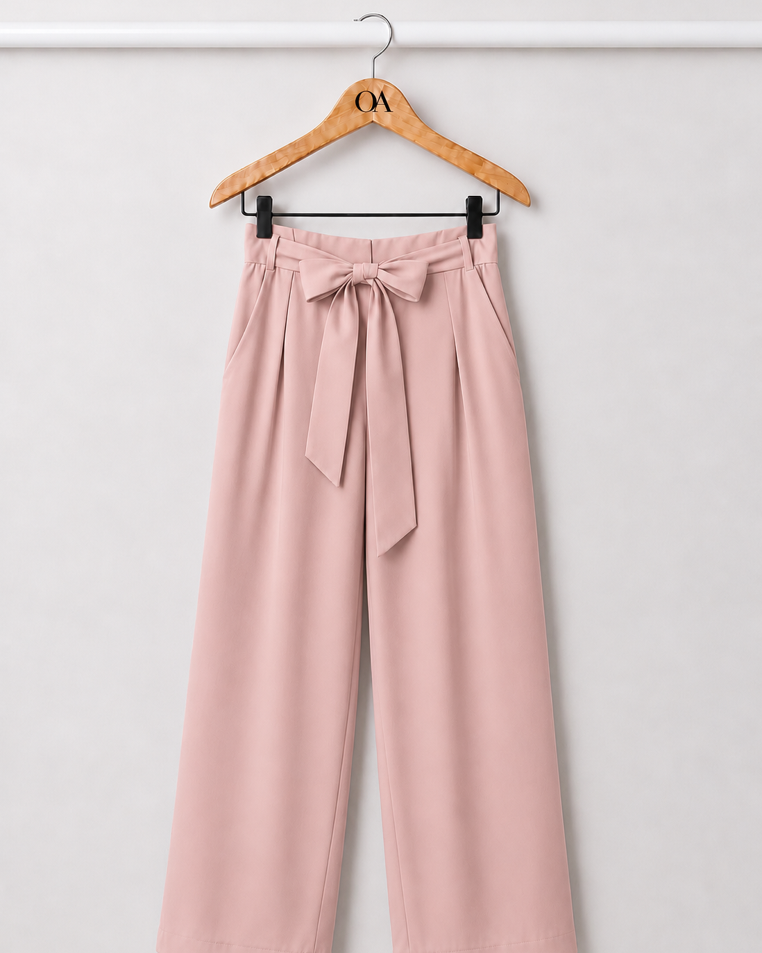 Calça rosa com laço na cintura e pernas amplas, com bolsos laterais