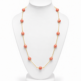 Colar longo de esferas coral com acabamento dourado e fecho discreto