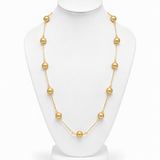 Colar longo de esferas douradas com acabamento dourado e fecho discreto