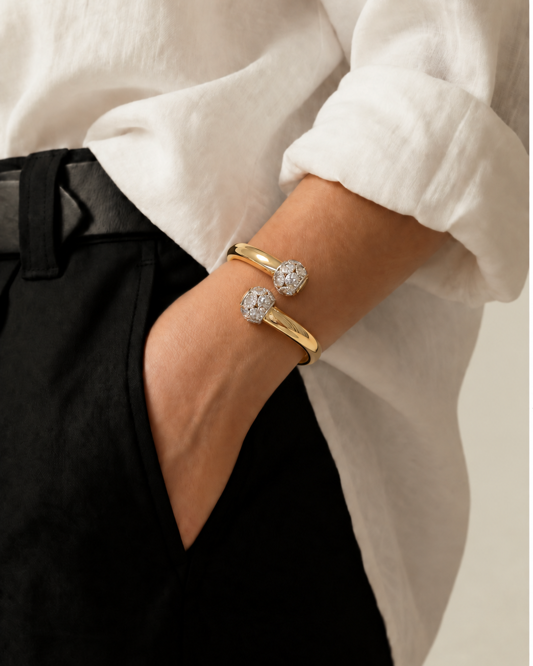 Pulseira dourada com duas pedras brilhantes no pulso, bracelete