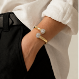 Pulseira dourada com duas pedras brilhantes no pulso, bracelete
