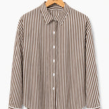 Camisa listrada vertical marrom e creme, gola e botões frontais, punhos ajustados.