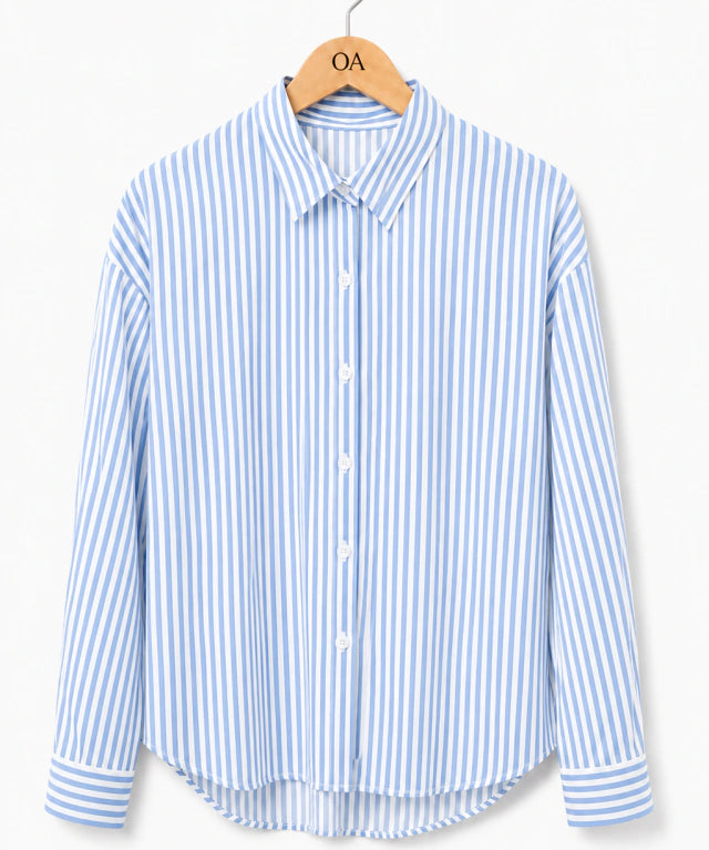 Camisa listrada vertical azul e branca, gola com botões frontais e punhos ajustados.