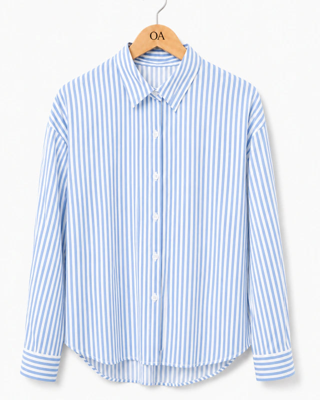 Camisa listrada vertical azul e branca, gola com botões frontais e punhos ajustados.
