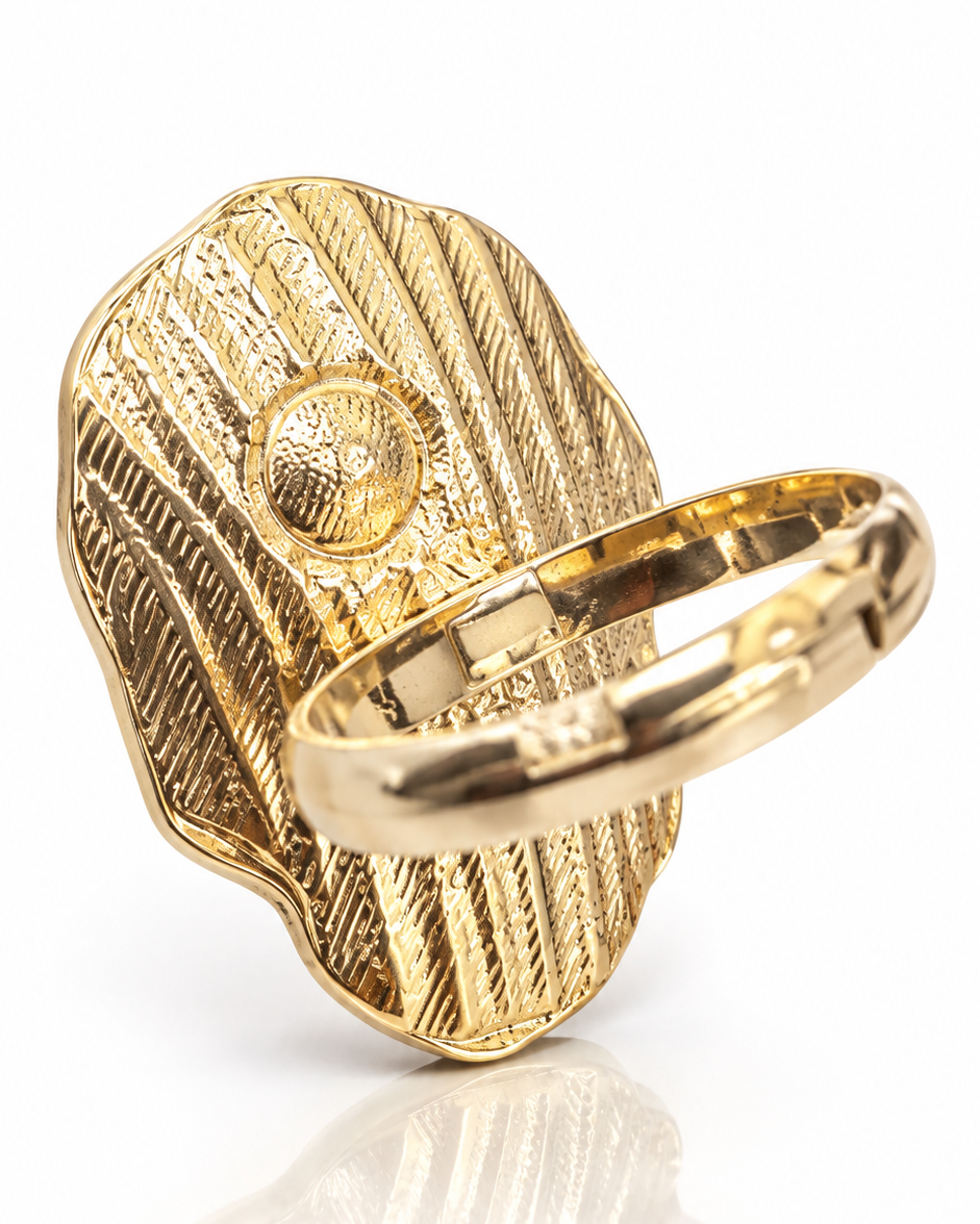 Anel dourado em formato de folha com detalhes gravados e flor central