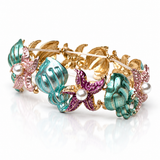 Pulseira dourada com berloques coloridos, esmalte azul e rosa, e pérolas brancas