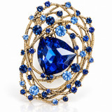 Broche Catarina dourado com pedras azuis e cristal azul em formato triangular