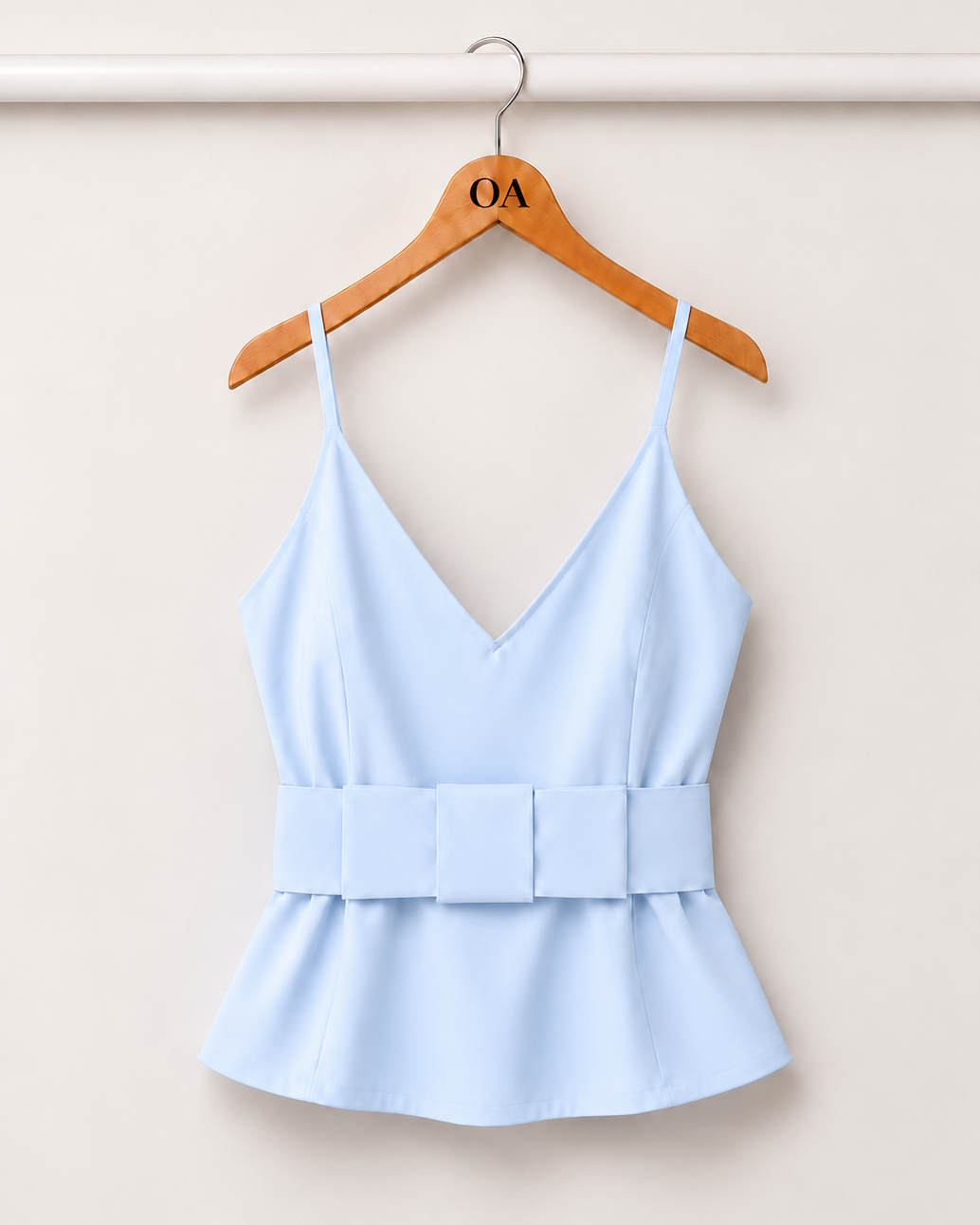 Blusa azul bebê com decote V e alças finas, cintura com faixa e babado