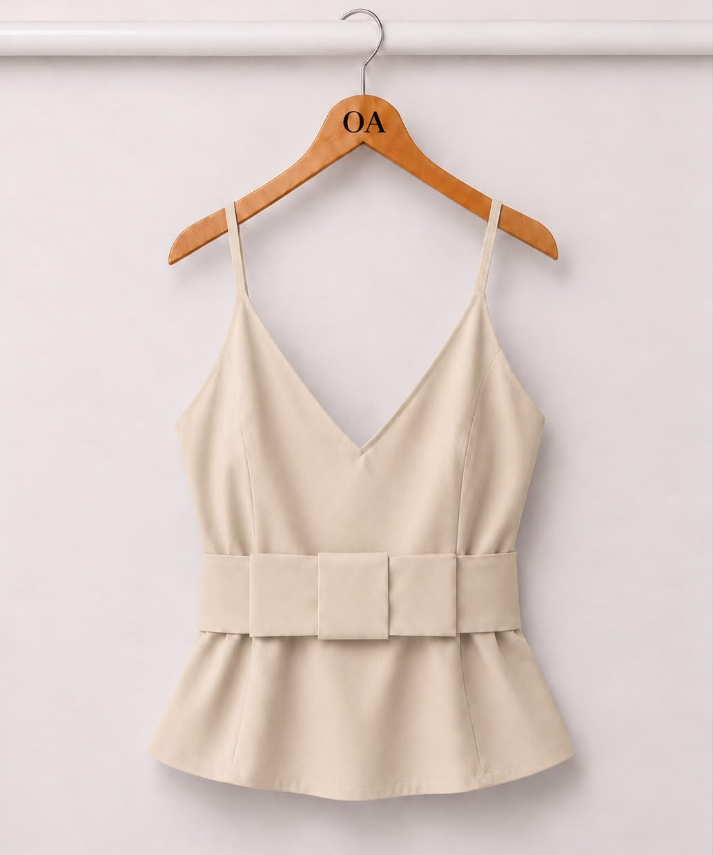Blusa creme com decote V e alças finas, faixa na cintura e babado