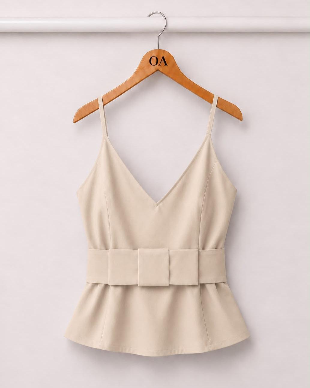 Blusa creme com decote V e alças finas, faixa na cintura e babado