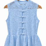 Blusa sem mangas azul clara de renda, abertura frontal com cinco botões e babado