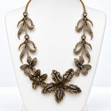 Colar maxi floral dourado com flores e pingentes cravejados