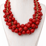 Colar vermelho de contas redondas com fecho dourado, estilo multiestágios.