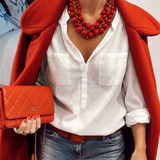 Colar vermelho de contas em camadas com detalhes dourados, usado no pescoço.