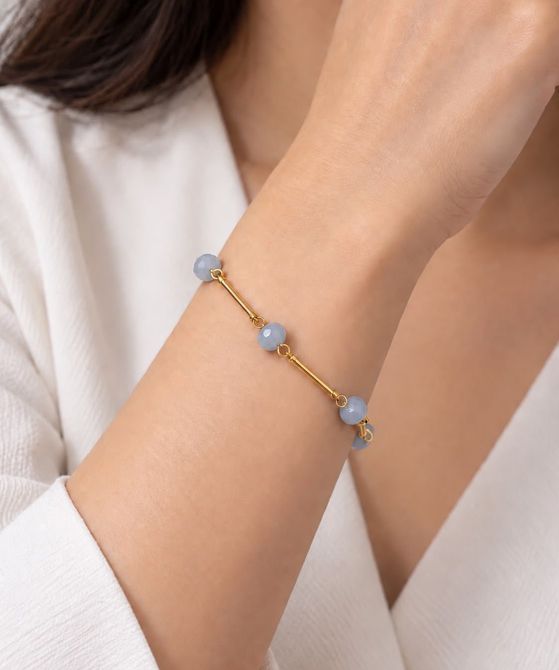 Pulseira dourada com contas azuis claras e fecho ajustável