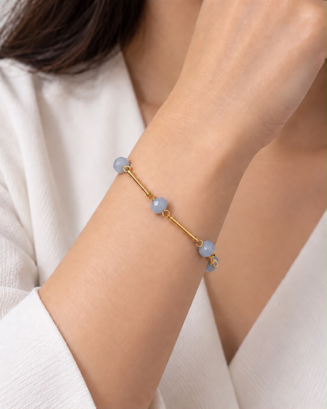 Pulseira dourada com contas azuis claras e fecho ajustável