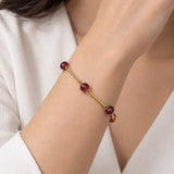 Pulseira dourada com pedras pequenas vinho