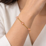 Pulseira dourada com pingentes pêssego e elos delicados no pulso